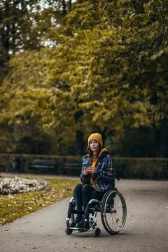 Woman with disability using a smartphone while out in the city park Stock Photos
