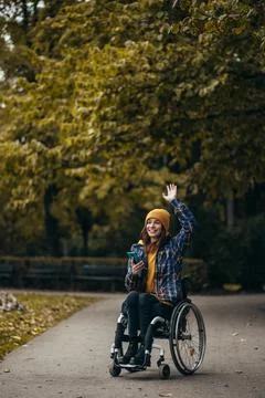 Woman with disability using a smartphone while out in the city park Stock Photos