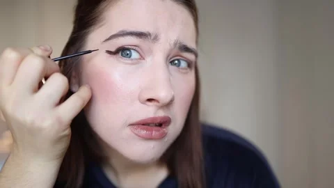 Woman discouraged while practicing uneven eyeliner Video stock 327217293