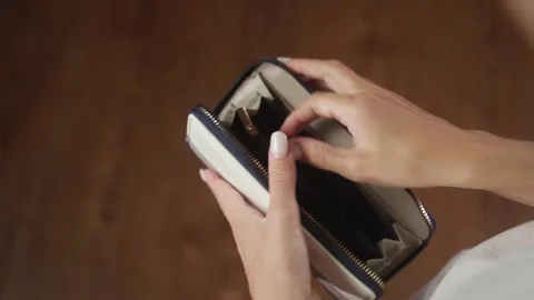 Woman displaying an empty wallet to highlight financial hardships Stock Footage 284845658