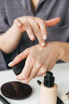 Woman do make up using foundation. Close up of the hand Stock Photos