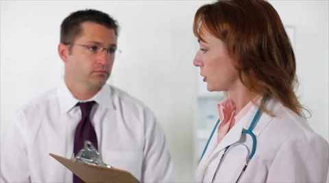 Woman doctor taking notes from a paitent Stock Footage