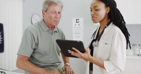 Woman doctor talking with senior patient in the office Stock Footage