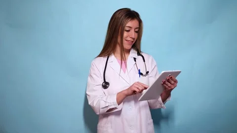 Woman doctor using digital tablet on light blue background Stock Footage 297675178