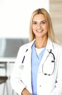 Woman-doctor at work in clinic excited and happy of her profession. Blond female Stock Photos
