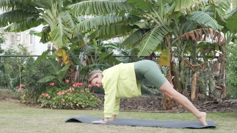 A woman does active yoga in the park in the summer. Turkey, Alanya Stock Footage 229965121
