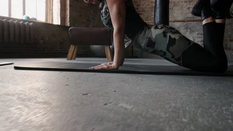 Woman does exercise on black mat watching training on laptop Stock Footage 211087397