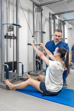Woman does exercise to stretch back muscles, rehabilitation after injury. Stock Photos
