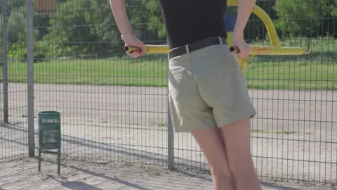 Woman does exercise for waist on simulator located on sports field in park. Video stock 249696052