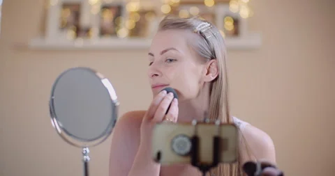 Woman does makeup during live session broadcast online Stock Footage 305046229