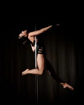 Woman does pole dance sport at home Stock Photos