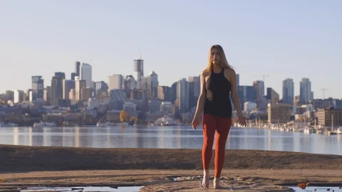 Woman Does a Yoga Tree Pose with Lake City Skyline Background Stock Footage 121435501