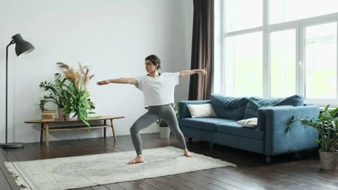 Woman Doing balance exercise doing Yoga, Sportswear Light Room At home Stock Footage 154597421