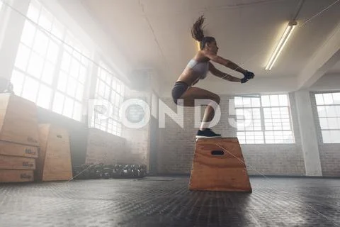 Woman doing a box squat at the gym Stock Photos