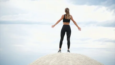 Woman doing a breathing exercise standing on stone, she looks into the distance Stock Footage