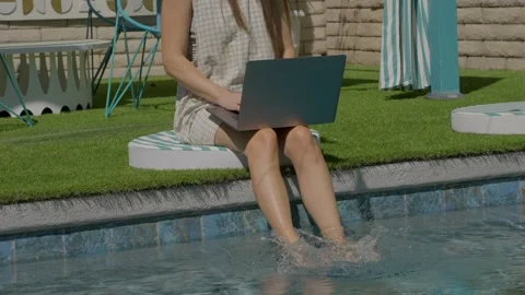 Woman doing computer work poolside Stock Footage 313703219