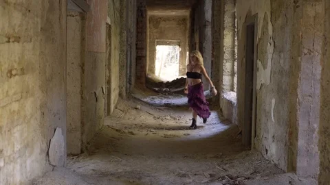 Woman doing a dance move in hall of abandoned place Stock Footage 102671153