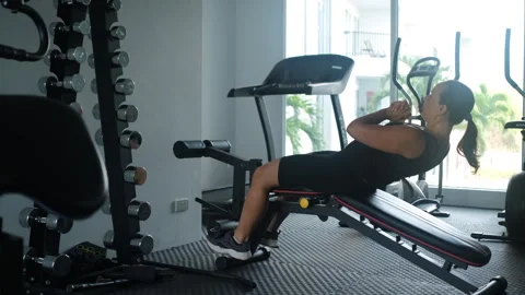 Woman doing decline sit-ups on gym bench Stock-Footage 335256206