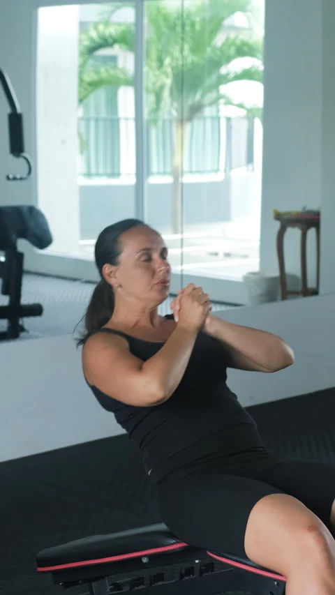 Woman doing decline sit-ups on gym bench Stock Footage 344097996