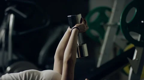 Woman doing a Dumbbell Pullover exercise on a bench in a gym Stock Footage 64575682