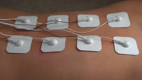 Woman doing electrical stimulation massage on her back Tens Stock Footage 150229748