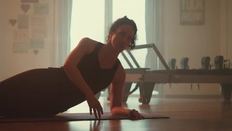 Woman doing exercise with floor mat reaching with her arm Stock Footage 275584895
