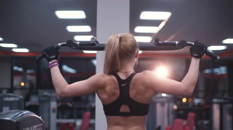 Woman doing exercise on the shoulders in the simulator Stock Footage 62229401