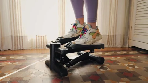Woman doing exercises on stepper at home, Close up of legs with sneakers. Stock Footage 314333896