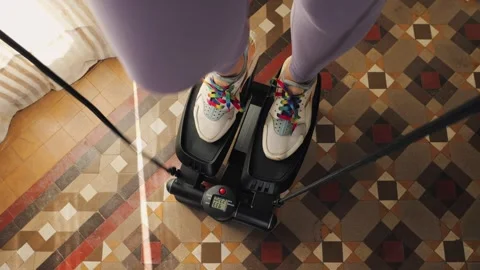 Woman doing exercises on stepper at home, Close up of legs with sneakers. Stock Footage 314333936