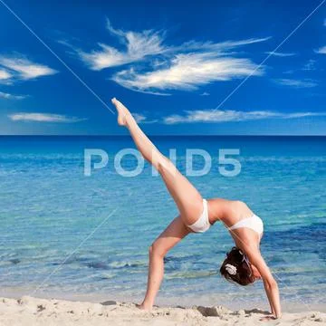 A woman is doing flexibility exercise in the sea Stock Photos