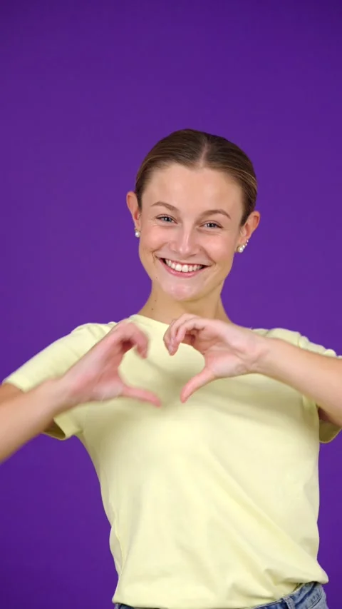 Woman doing heart shape isolated on purple Stock Footage 253164530