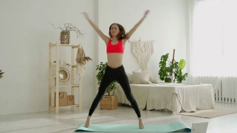 Woman doing jumping jacks exercise at ho... | Stock Video | Pond5