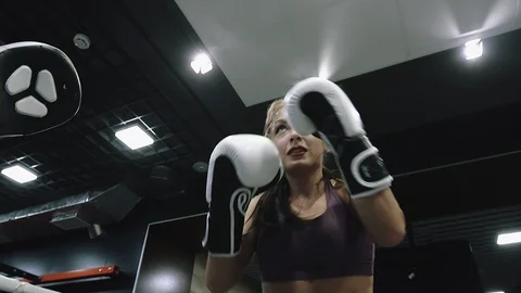 Woman is doing kickboxing training to practicing hand punches in gloves in gym. Stock Footage 107183391