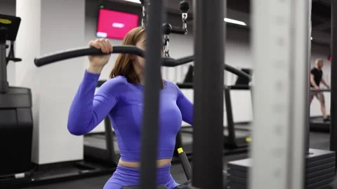 Woman doing lat pulldown Stock Footage 328995880