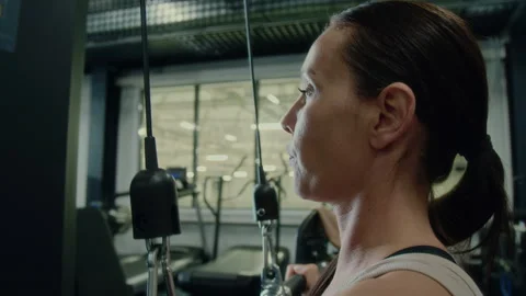 Woman Doing Lat Pulldowns on Exercise Machine in Gym Stock Footage 285658208