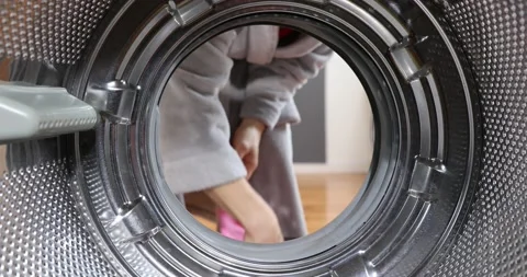 Woman doing laundry. View Looking Out From Inside Washing Machine As Woman Ta Stock Footage 152856071