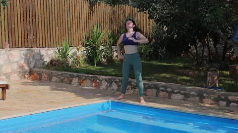Woman doing a light workout in the pool garden Stock Footage 221086887