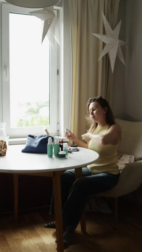 Woman Doing Makeup at Home Table by Window Stock Footage 337093566