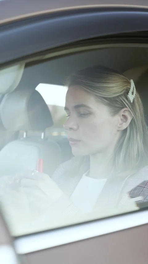 Woman doing makeup while sitting in a car Stock Footage 274314591