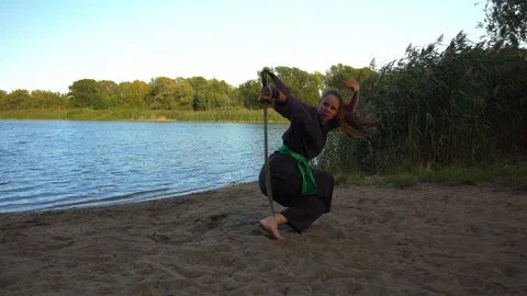 Woman doing martial arts training at lake beach Stock Footage 141271253
