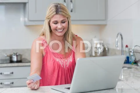 Woman doing online shopping in the kitchen Stock-Fotos
