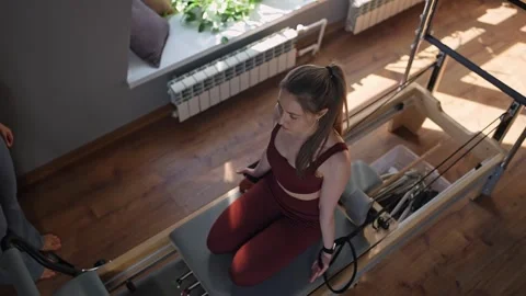 Woman doing pilates exercise on Pilates Reformer for the chest, arms biceps and Stock Footage 341734917