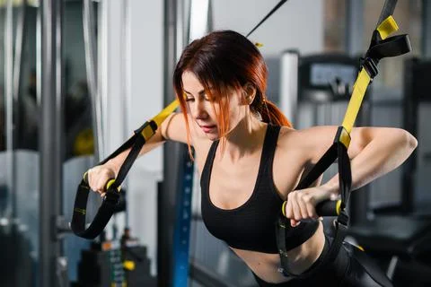 Woman doing push ups with trx fitness straps Stock Photos