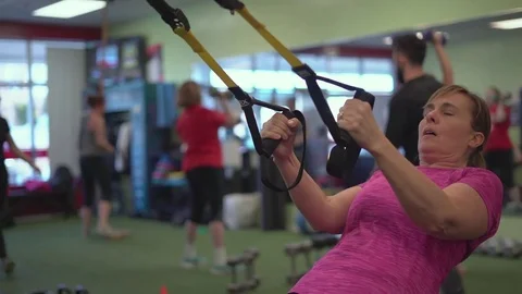 Woman doing risistance work in a busy gym Stock Footage 73183286