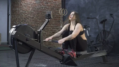 Woman doing rowing machine workout Stock Footage 72890624
