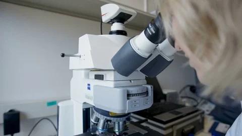 Woman doing science test with a microscope at her workplace, see Stock-Footage 75445217