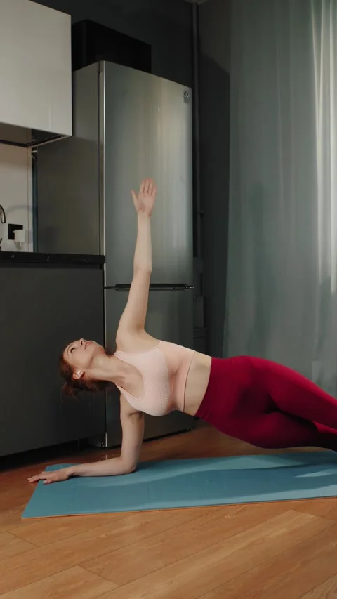 Woman doing side plank exercise on yoga mat at home Vídeos de archivo 319442903