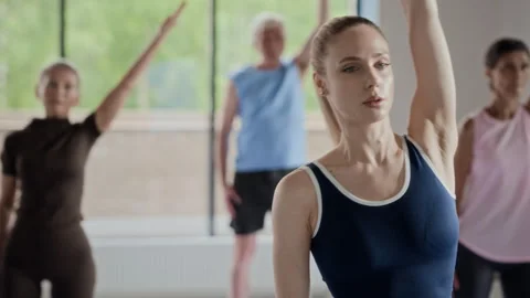 Woman Doing Side Stretch in Group Fitness Class Stock Footage 339858731
