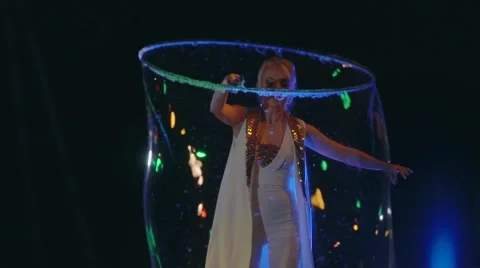Woman is doing soap bubble show on the black background Video stock 67585582