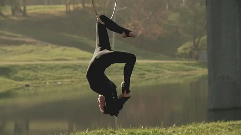 Woman doing some acrobatic elements on aerial hoop outdoors. Flexible girl Stock Footage 104765346